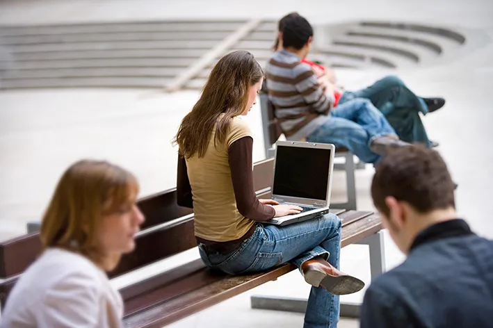 Studierende mit Laptops beim mobilen Arbeiten.