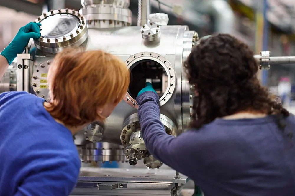 Zwei Frauen schauen auf ein Gerät aus Metall