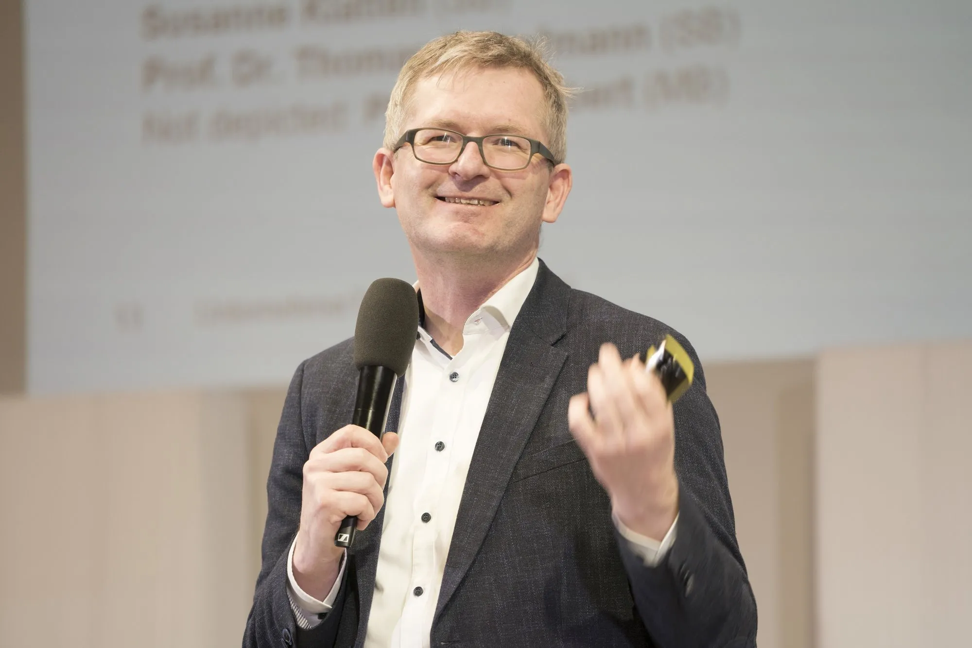 Mann mit Mikro in der einen Hand