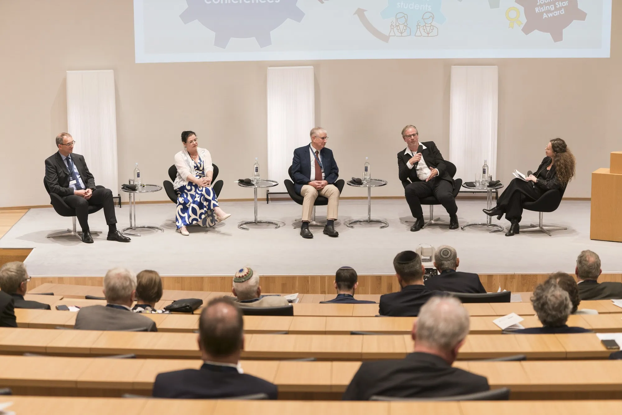 Podiumsdiskussion mit fünf Teilnehmenden auf der Bühne