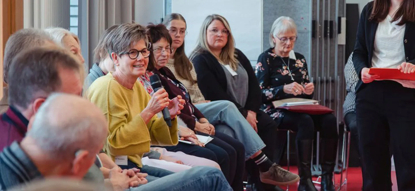 Diskussionsrunde mit mehreren Personen unterschiedlichen Alters