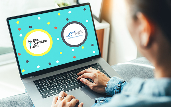 eine Person schaut auf den Bildschirm eines Laptops, darauf das MFF Logo