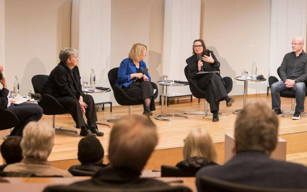 Fünf Menschen sitzen auf einer Bühne.