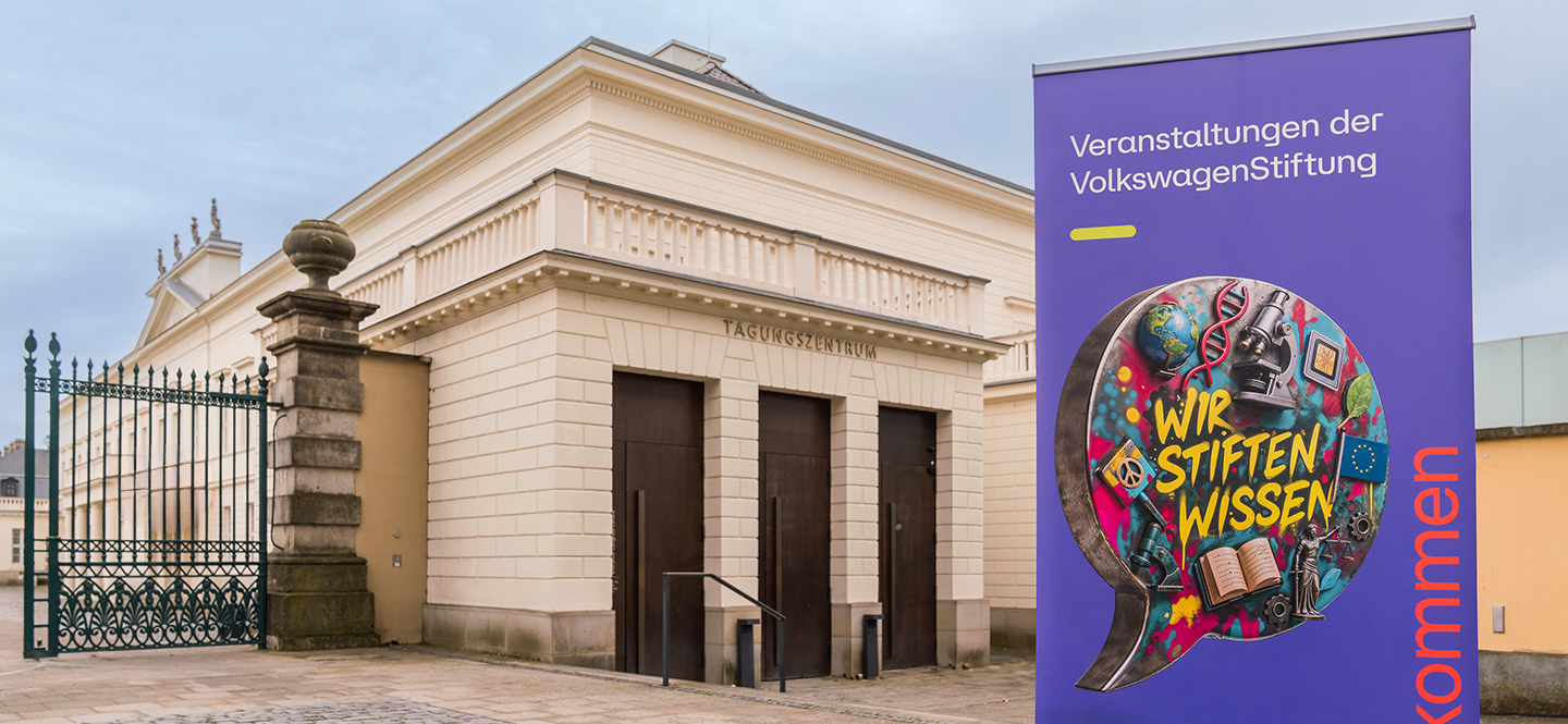 Aufsteller mit Aufdruck "Wir stiften Wissen" in Sprechblase, im Hintergrund der Eingang ins Schloss Herrenhausen