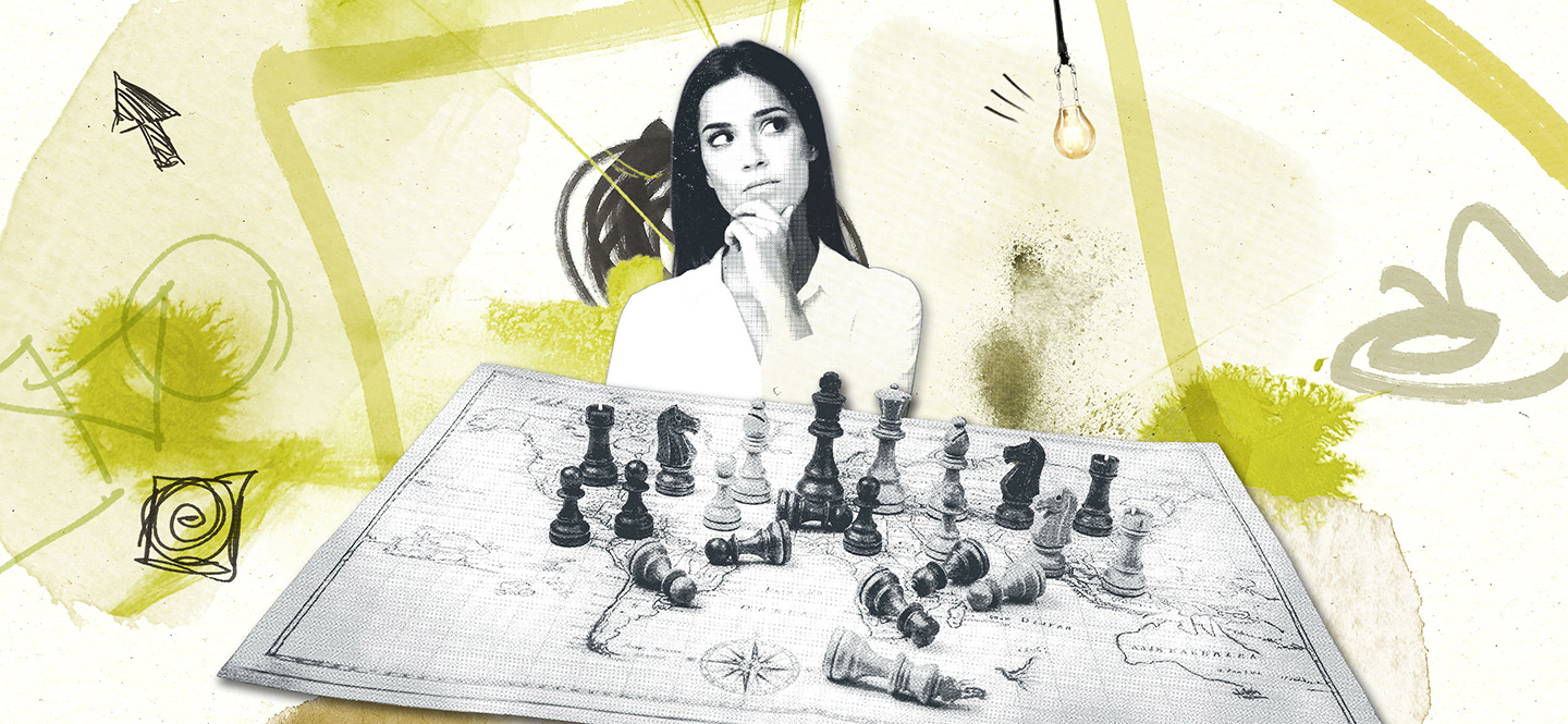 Frau blickt nachdenklich über Weltkarte auf der Schachfiguren stehen und liegen