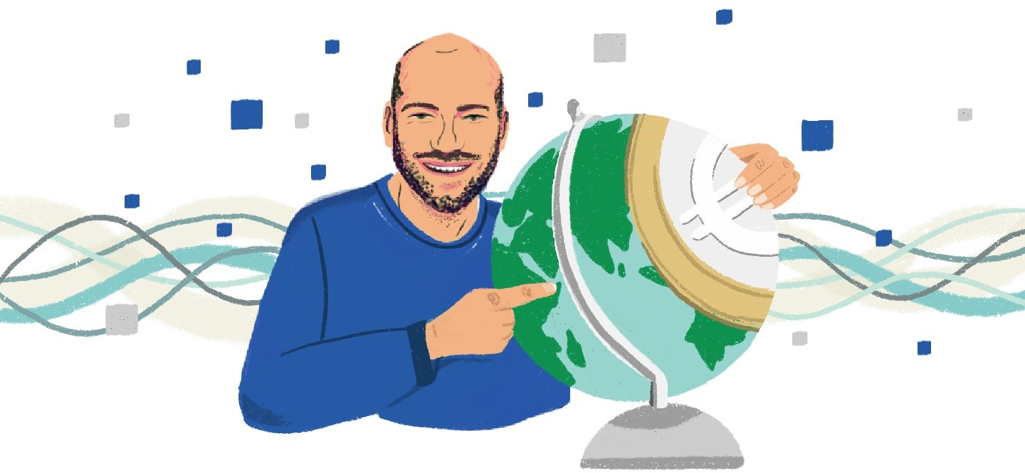 Ein Mann hält einen Globus im Arm und zeigt darauf.