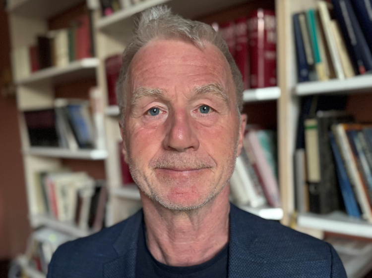 Das Foto zeigt Prof. Dr.Thomas König vor einem Bücherregal