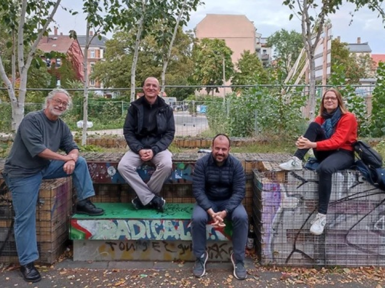 Vier Menschen sitzen auf einer Mauer