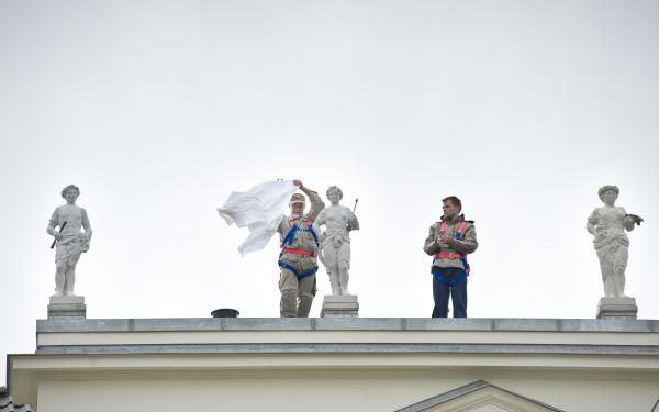 zwei Personen auf dem Dach des Schlosses, daneben drei Gipsfiguren