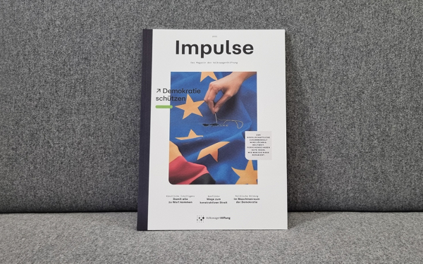 Ein Magazin mit dem Titel "Impulse" liegt auf einem grauen Sofa
