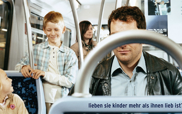 Kinder in einer U-Bahn mit einem Mann mit verdeckten Augen.