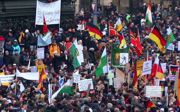 Demonstrierende Menschen mit Fahnen und Plakaten
