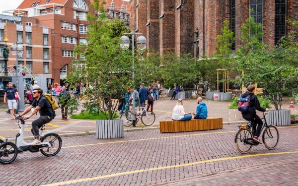 Menschen bewegen sich durch die Innenstadt von Hannover, die zusätzlich begrünt und mit Bänken ausgestattet ist.