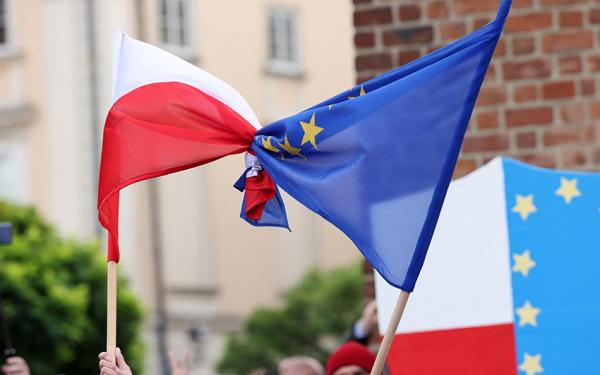 Die polnische und die europäische Flagge ineinander verknotet werden hochgehalten.