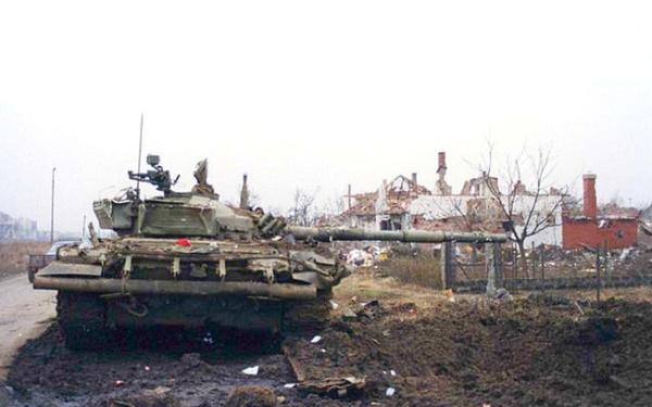 Ein zerstörter jugoslawischer Panzer steht in einem Kriegsgebiet.