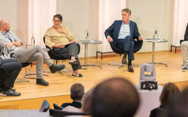 Podium mit fünf Personen in einer Diskussionsrunde