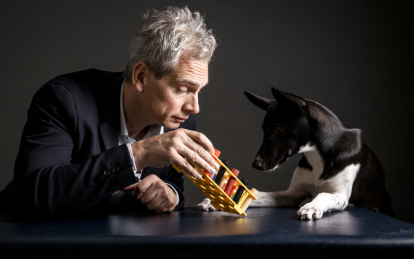Das Bild zeigt Prof. Holger Volk mit Spürhund, der an Duftröhrchen riecht