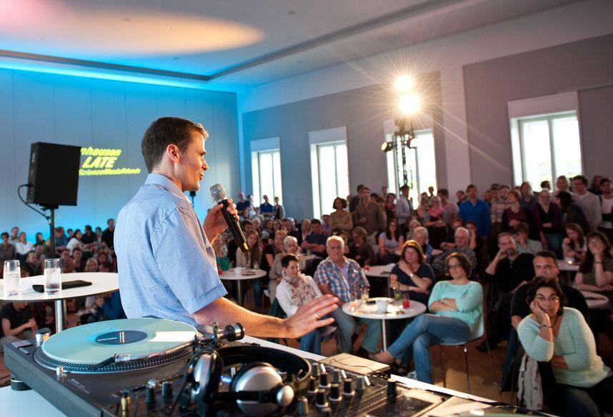 Ein Mann auf dem Podium, im Hintergrund der Schriftzug "Herrenhausen Late"