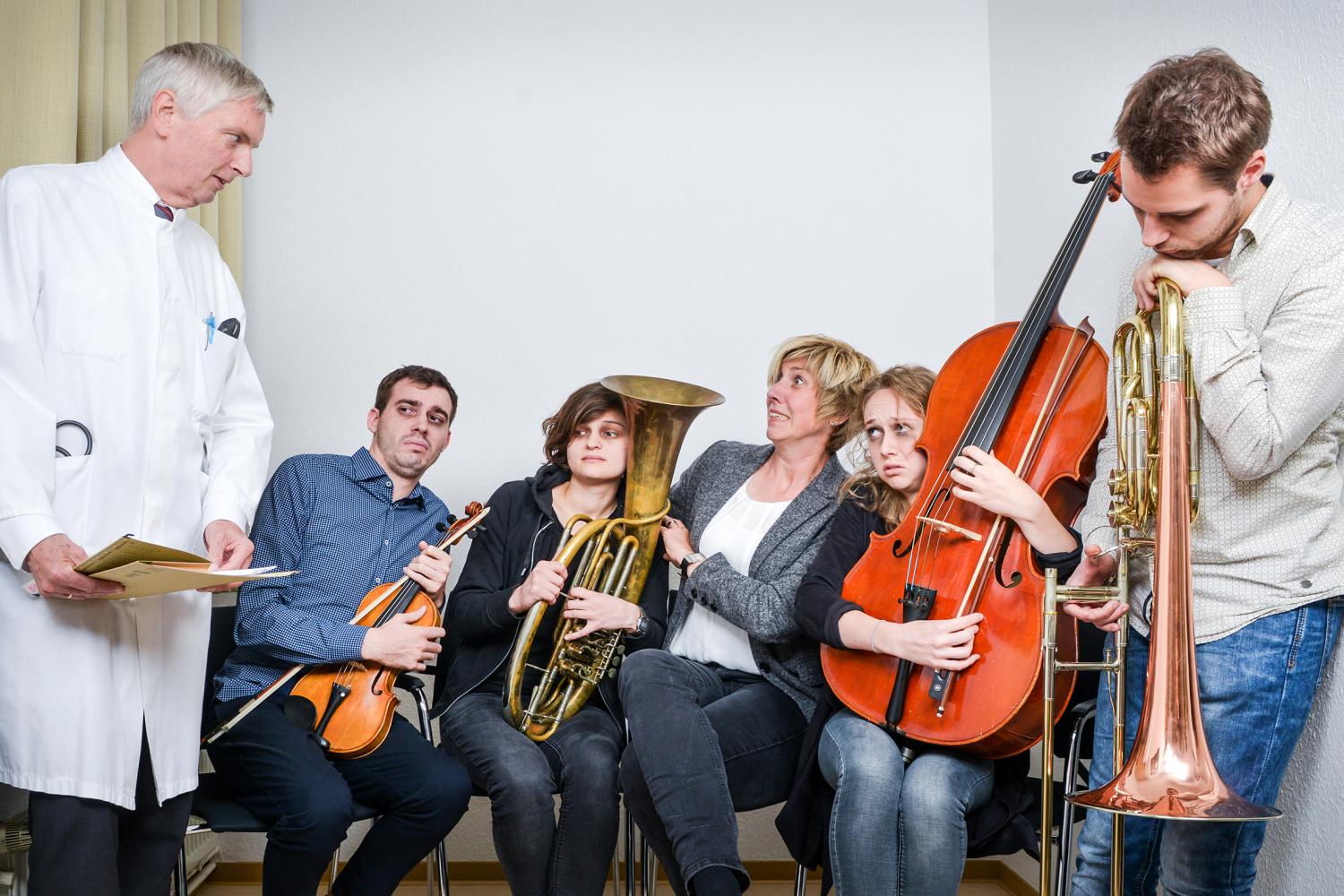 Musiker mit verschiedenen Instrumenten, daneben ein streng blickender Arzt