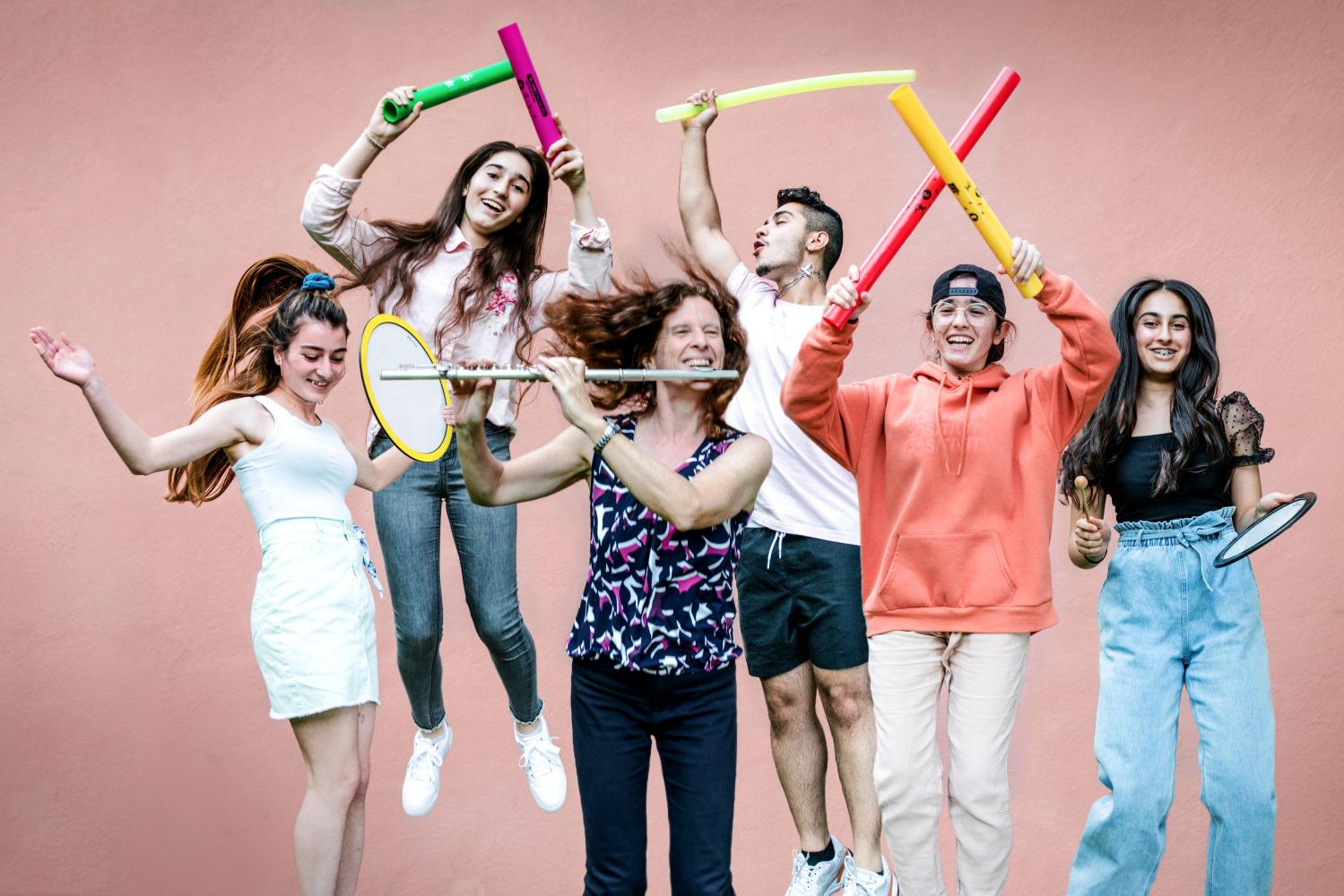 junge Menschen mit verschiedenen Instrumenten springen in die Luft