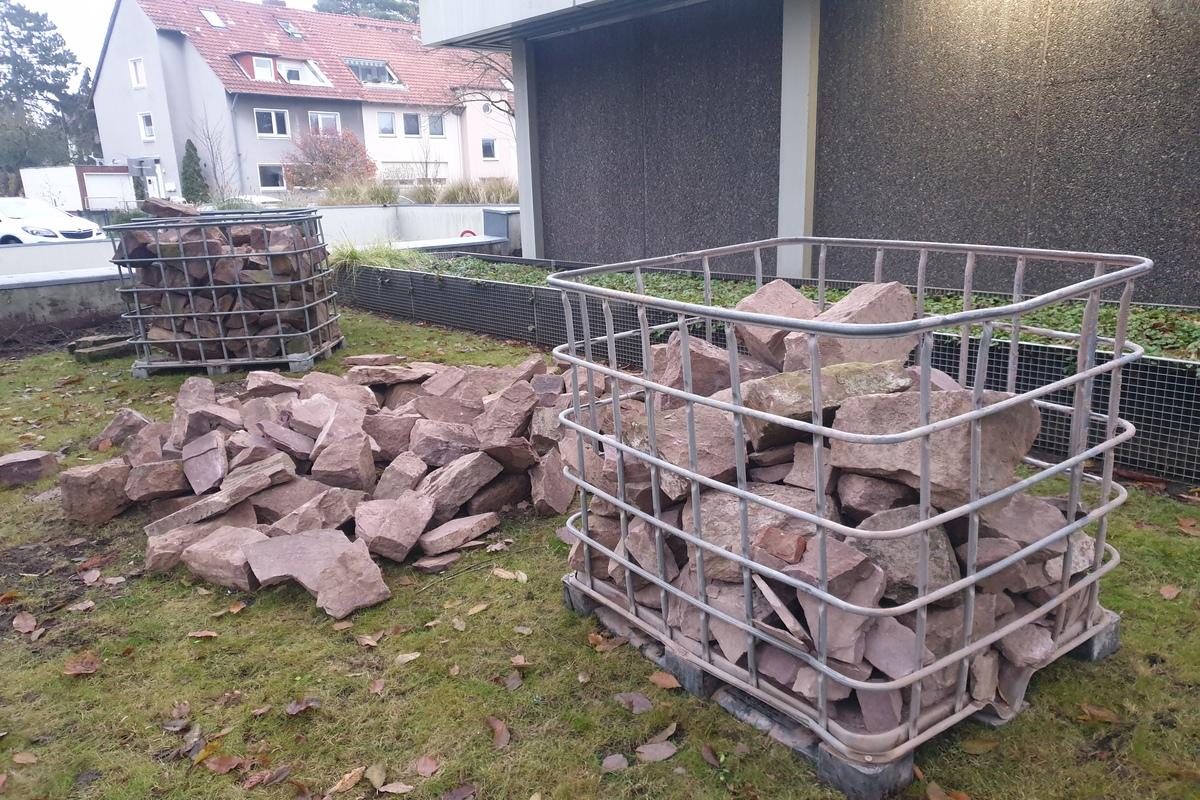 Steinhaufen und Transportkorb voller großer Steine