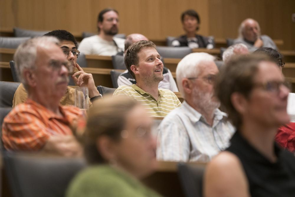 Zuhörer:innen in einem Auditorium