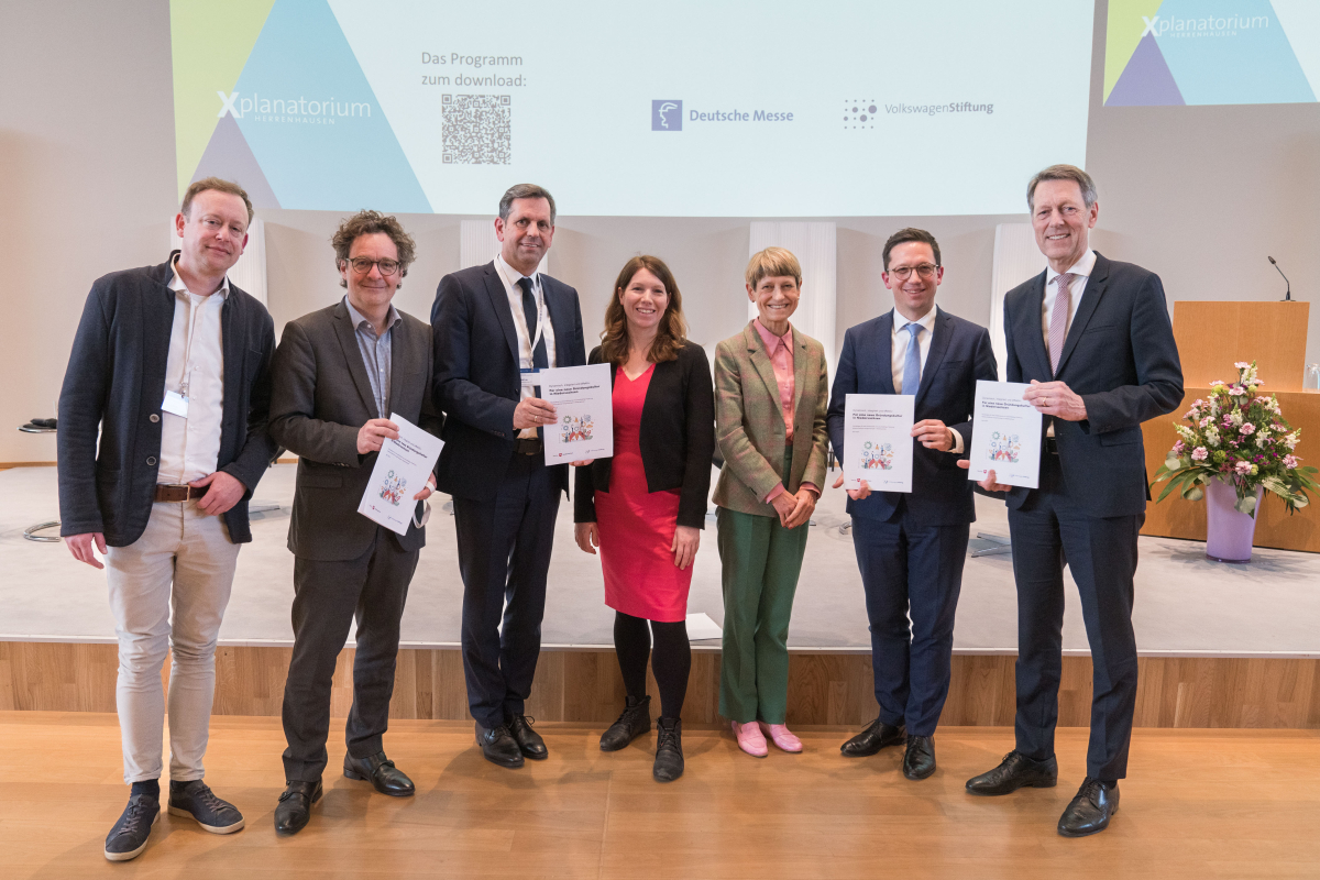 sieben Personen, alle halten das gleiche Dokument in der Hand