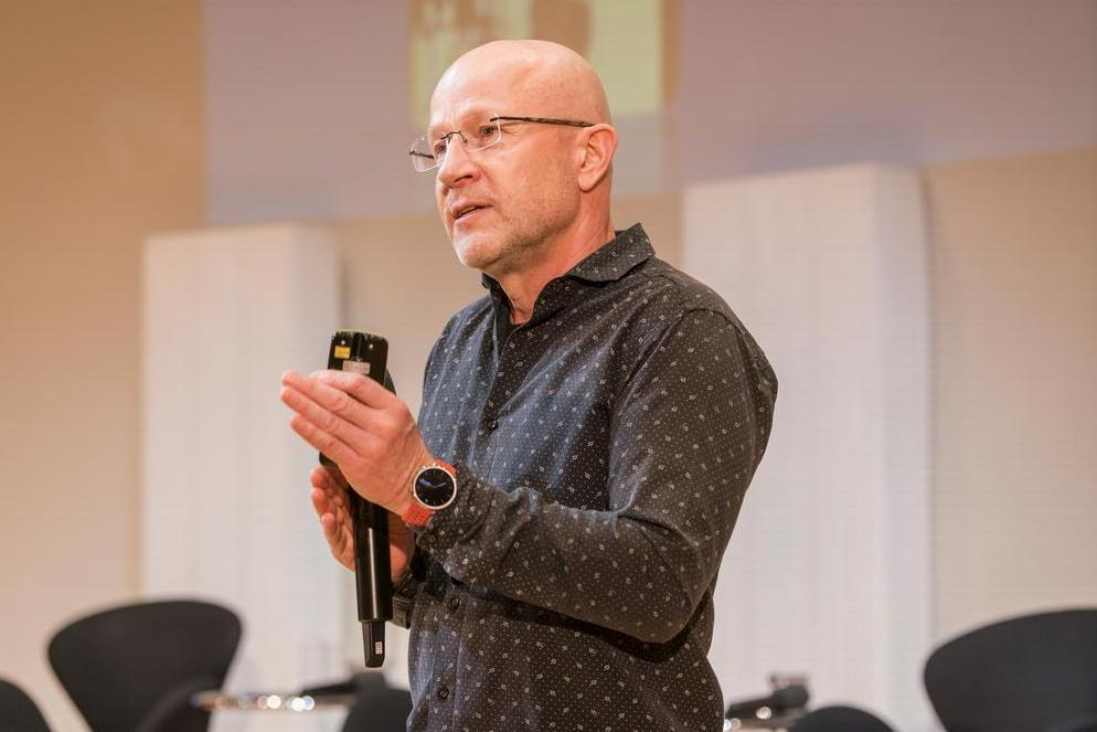 Ein Mann hält ein Mikrophon in der Hand.