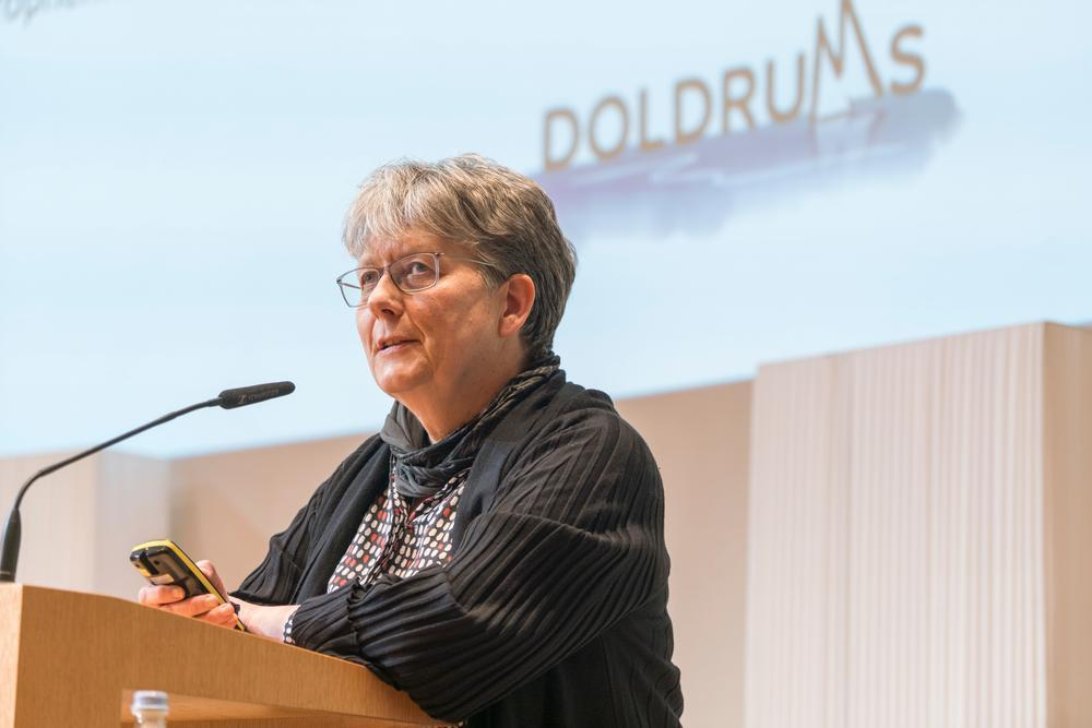 Eine Frau steht auf einer Bühne.