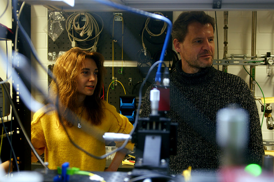 Mann und Frau, umgeben von Kabeln in einem dunklen Labor