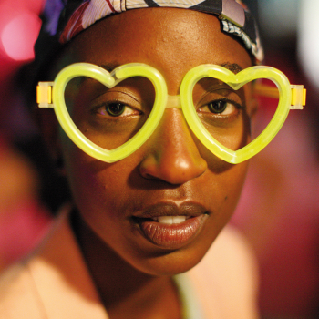 Das Bild zeigt eine junge, moderne Afrikanerin mit einer großen herzförmigen Sonnenbrille.