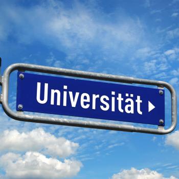 Wegweiser Universität vor blauem Himmel 