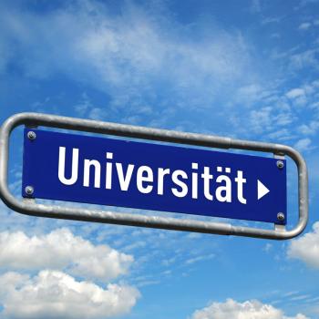 Wegweiser Universität vor blauem Himmel 