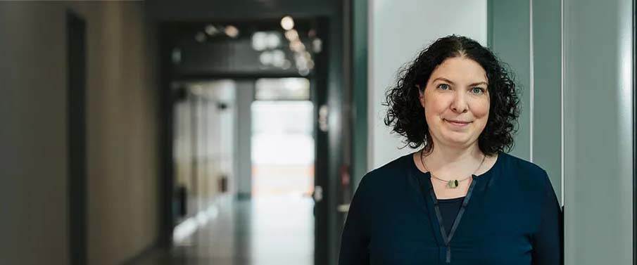 Frau steht in einem langen Flur