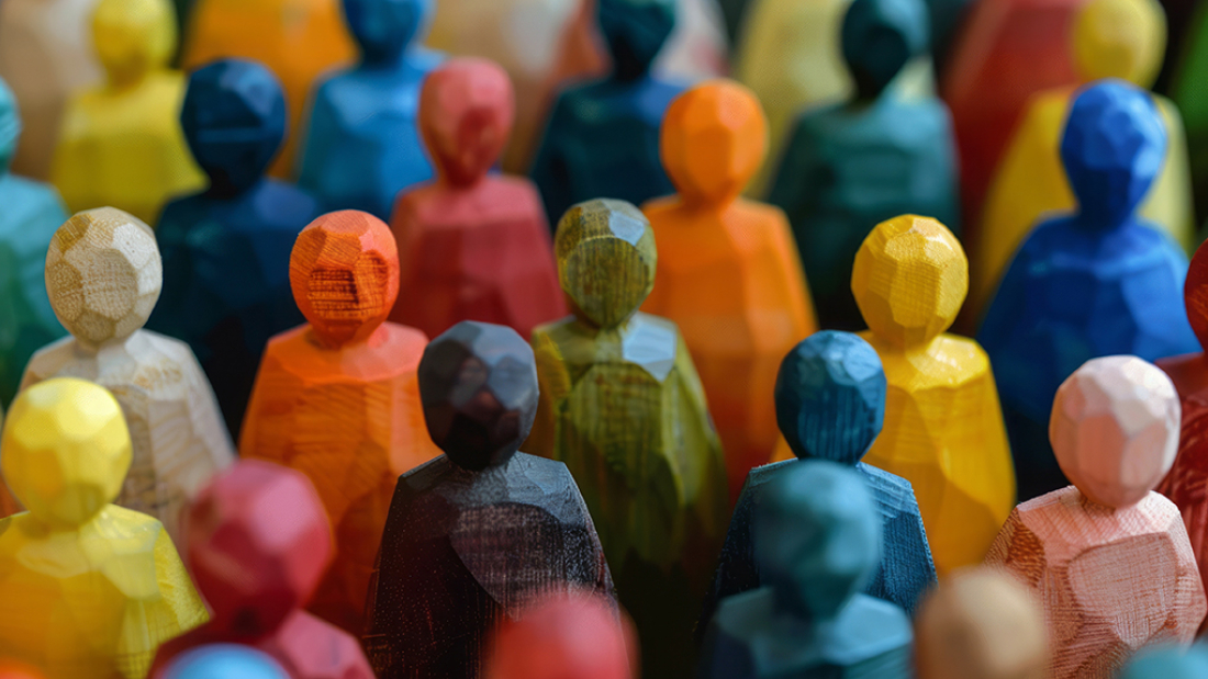 Das Bild zeigt eine Gruppe hölzerner Spielfiguren in unterschiedlichen Farben.